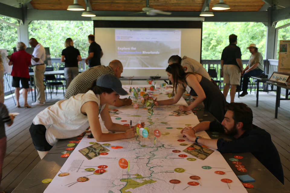 landscape photo of people gathered around a table reviewing annotated map