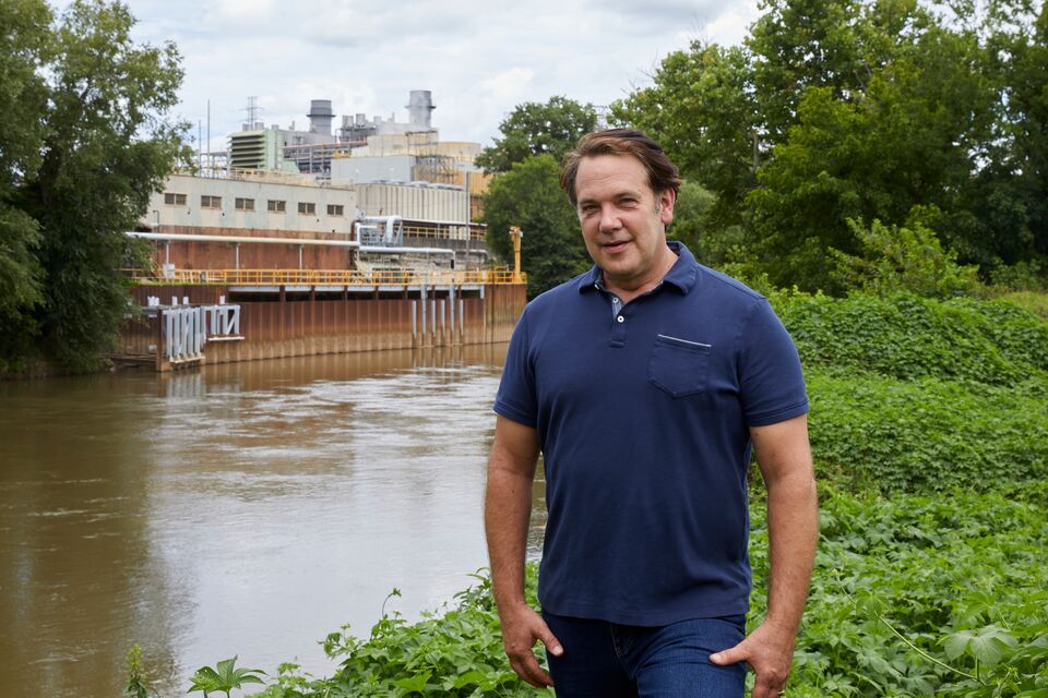  landscape orientation portrait of Walt Ray in front of a factory along the river