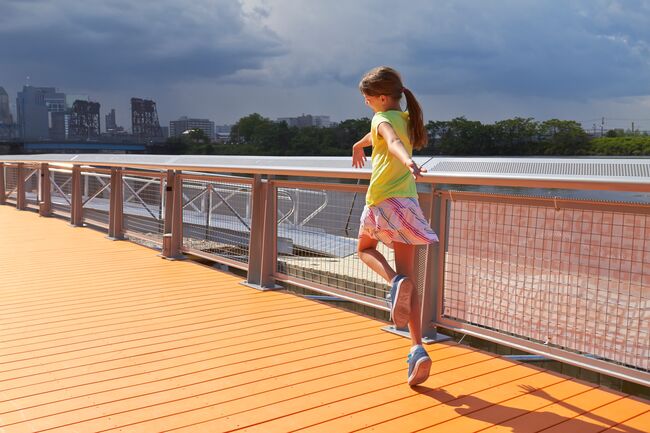 Skipping along the orange boardwalk at Newark Riverfront Park in Newark, NJ Skipping along the orange boardwalk at Newark Riverfront Park in Newark, NJ