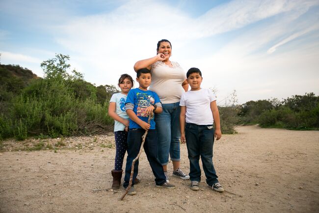 A mom and three kids on a trail